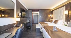 a hotel room with two beds and a teddy bear on the bed at Best Western Plus Plaza Hotel Darmstadt in Darmstadt