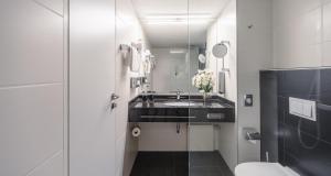 a white bathroom with a sink and a toilet at Best Western Plus Plaza Hotel Darmstadt in Darmstadt