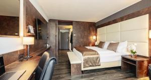 a hotel room with a bed and a desk at Best Western Plus Plaza Hotel Darmstadt in Darmstadt