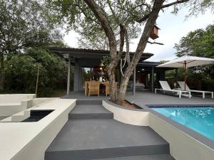 a backyard with a swimming pool and a house at The Cabin Luxury Safari Villa in Somerset