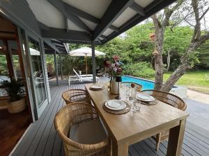 a wooden table and chairs on a deck at The Cabin Luxury Safari Villa in Somerset
