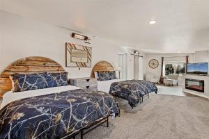 ein Schlafzimmer mit zwei Betten und einem Flachbildfernseher in der Unterkunft Amazing Views Central AC 5 ac of Privacy Lawn Games and HOT TUB in Elden Pueblo