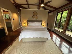 a bedroom with a large white bed and windows at The Cabin Luxury Safari Villa in Somerset +27 photos
