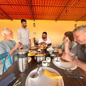 un groupe de personnes assises autour d'une table en train de manger dans l'établissement Pukhraj Garh, à Jodhpur