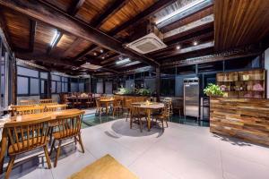 a restaurant with wooden ceilings and tables and chairs at Shenshan Wild Escape （Lure Fishing and More） in Qingshan