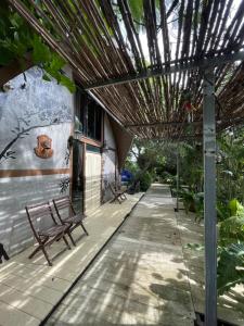 a patio with two benches and a pergola at บ้านนกฮูก อิงสายชล in Ban Khlong Sai