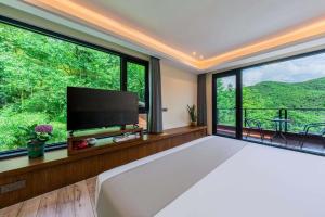 a bedroom with a large bed and a large window at Shenshan Wild Escape （Lure Fishing and More） in Qingshan