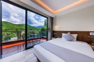 a bedroom with a bed and a balcony with a view at Shenshan Wild Escape （Lure Fishing and More） in Qingshan +66 photos