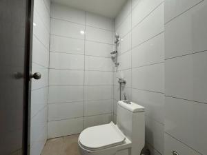 a bathroom with a toilet and a white tiled wall at Swing & Pillows - CIQ Johor Bahru in Johor Bahru +16 photos