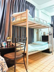 een slaapkamer met 2 stapelbedden en een stoel bij Regalohome Br in Bangkok