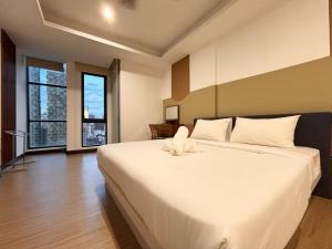 a large white bed in a room with windows at Casa Residency Bukit Bintang by PILLOWTALKS in Kuala Lumpur