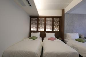 zwei Betten in einem Zimmer mit zwei Fenstern in der Unterkunft Tradiup Hotel by the Designers in Seoul