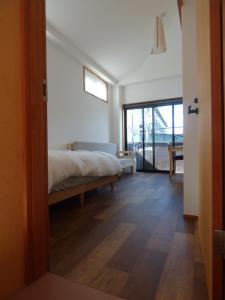 Un dormitorio con una cama y una puerta corrediza de vidrio. en Guesthouse Hyakumanben Cross, en Kioto
