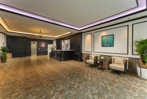 a lobby with chairs and a podium in a building at Grand Vĩnh Tuy Hanoi Hotel&Spa in Mai Phúc