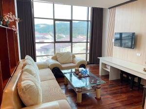 a living room with a couch and a table at Anoulack Khen Lao Hotel in Muang Phônsavan