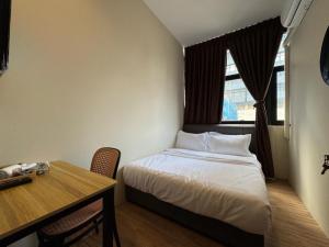 a bedroom with a bed and a desk and a window at Swing & Pillows - CIQ Johor Bahru in Johor Bahru