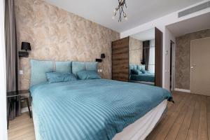 ONYX 57 - Elegant City Apartment in Bucharest في بوخارست: غرفة نوم بسرير كبير مع لحاف ازرق