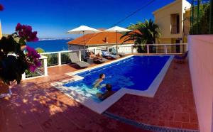 a swimming pool with people sitting in it on a house at Villa Marija in Marina
