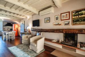 a living room with a fireplace with two chairs at Il Mazzocchio - Lucca Centro in Lucca