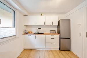 a kitchen with white cabinets and a refrigerator at CharmÖHR Homes in Öhringen