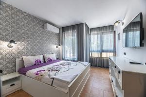 金沙Beach Front Suites SEAVIEW BG的卧室里有一张铺着紫色床单的大床 更多170张照片