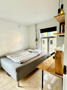 een slaapkamer met een bed en een houten tafel bij Charming in the center of Hamar in Hamar