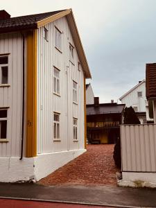 een wit en geel gebouw aan een bakstenen straat bij Charming in the center of Hamar in Hamar