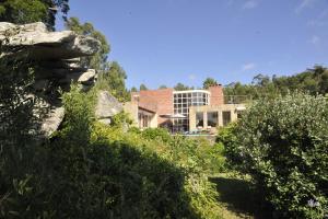 a house on a hill with trees and bushes at Casa Penedo da Saudade in Afife