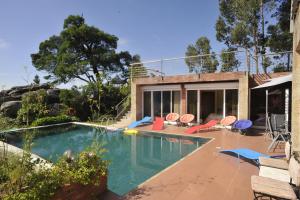 a swimming pool with chairs and a house at Casa Penedo da Saudade in Afife