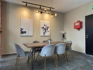 a dining room with a wooden table and chairs at Swing & Pillows - CIQ Johor Bahru in Johor Bahru