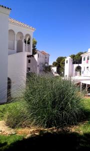 a white house with tall grass in front of it at APCOSTAS - Complejo Al Andalus in Alcossebre