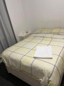 オールダムにあるCooperate home2の黄色と青のチェック柄の毛布が掛けられたベッド +5枚の写真