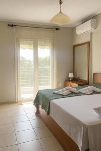 a bedroom with a bed and a large window at Epanomi Apartments in Epanomi