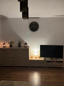 een woonkamer met een tv en een klok aan de muur bij Apartament w Centrum Malborka in Malbork +20 foto's