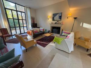 Una sala de estar con sofás y chimenea. en Bastide Terrieu - domaine avec piscine et terrain de boules, climatisation, en Saint-Mathieu-de-Tréviers