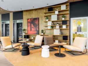 a waiting room with chairs and tables and shelves at ibis Hotel Hamburg St. Pauli Messe in Hamburg +105 photos