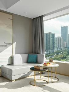 a living room with a white couch and a table at Shenzhen Grand Skylight Garden Hotel in Shenzhen