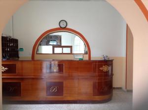 un escritorio de madera con un reloj encima en Hostal Buenos Aires, en Quito