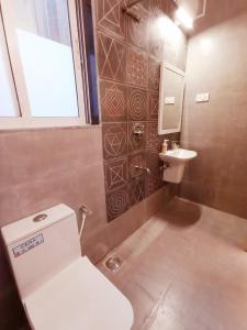 een badkamer met toilet en wastafel bij Spacious Condo with Pool View in Anjuna