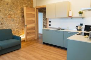 a kitchen with blue cabinets and a blue chair at Corte Bonfiglio Colombari in Illasi