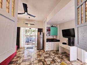 een keuken met een koelkast en een tv in een kamer bij Spacious Condo with Pool View in Anjuna