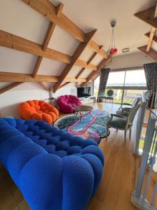 een woonkamer met een blauwe bank en stoelen bij Beautiful master villa in Fontenay-sous-Bois