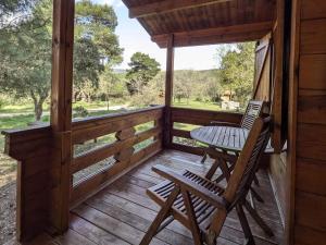 a wooden porch with a table and a chair on it at Cabañas Llano de los Conejos in Cañamares +143 photos