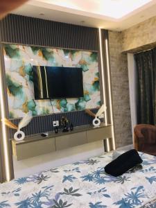 a bedroom with a bed and a flat screen tv at Suite with Private Jacuzzi in Ghaziabad