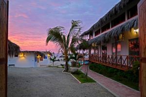 a building with a palm tree in front of the water at Palo Santo Beach club in Bocapán