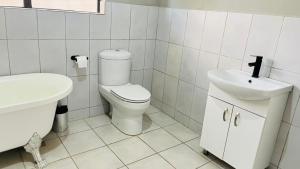 a white bathroom with a toilet and a sink at The Perazim Place in Hazyview +10 photos