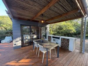 a patio with a table and chairs on a deck at The Dome Luxury Safari Villa in Hluhluwe