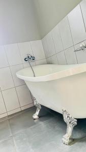 a white bath tub sitting in a bathroom at The Perazim Place in Hazyview
