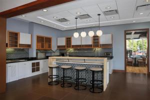 ローリーにあるHyatt Place Raleigh Caryのスツール付きのバーカウンターのあるキッチン