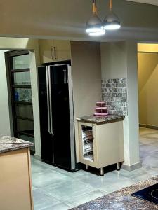 a kitchen with a black refrigerator in a room at The Perazim Place in Hazyview